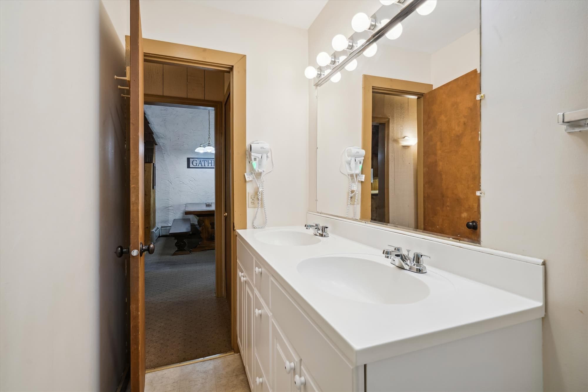 This bathroom has a well lit vanity area.