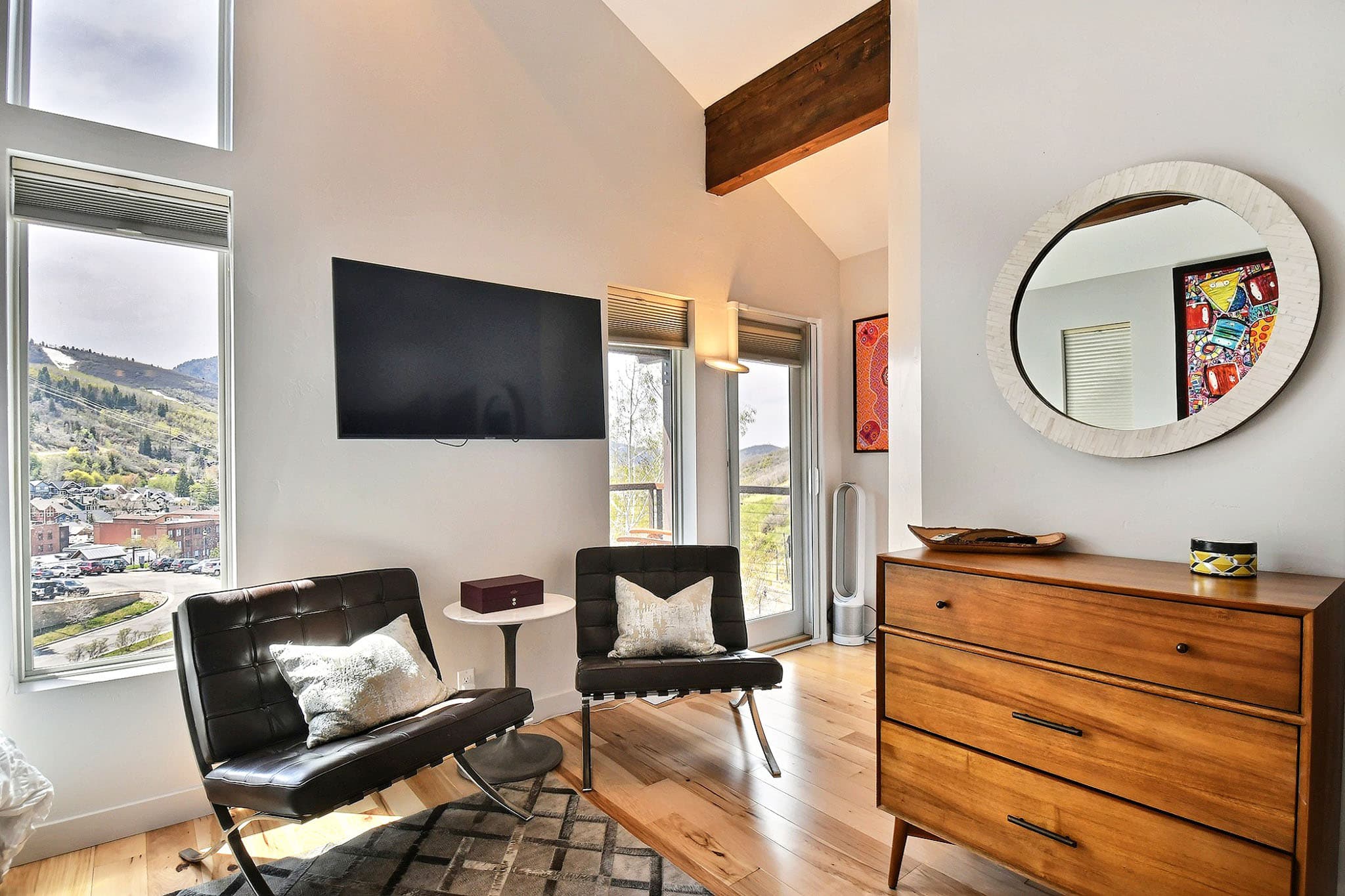 Two Leather Chairs, TV, and Dresser in a Bedroom