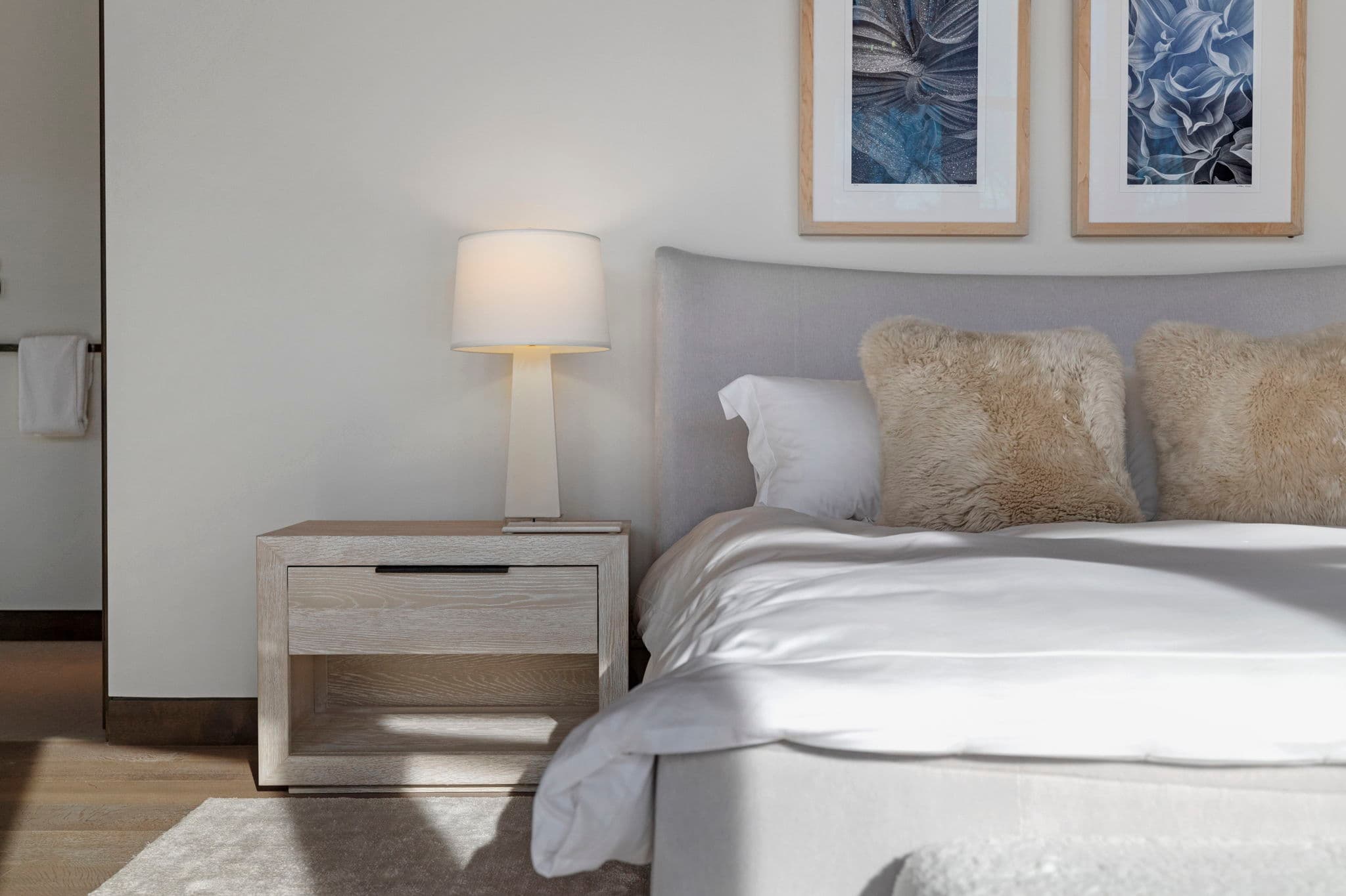 A bedroom with a bed, a side table, and a lamp.