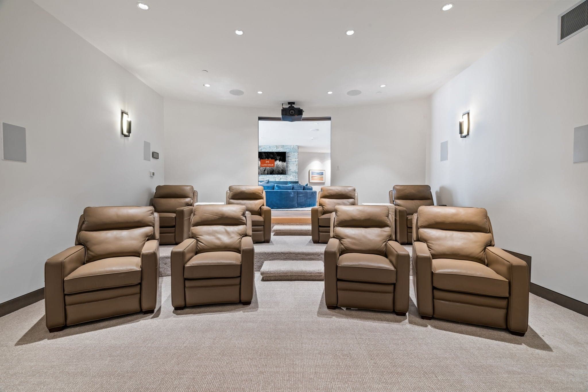 A large theater room with reclining chairs.