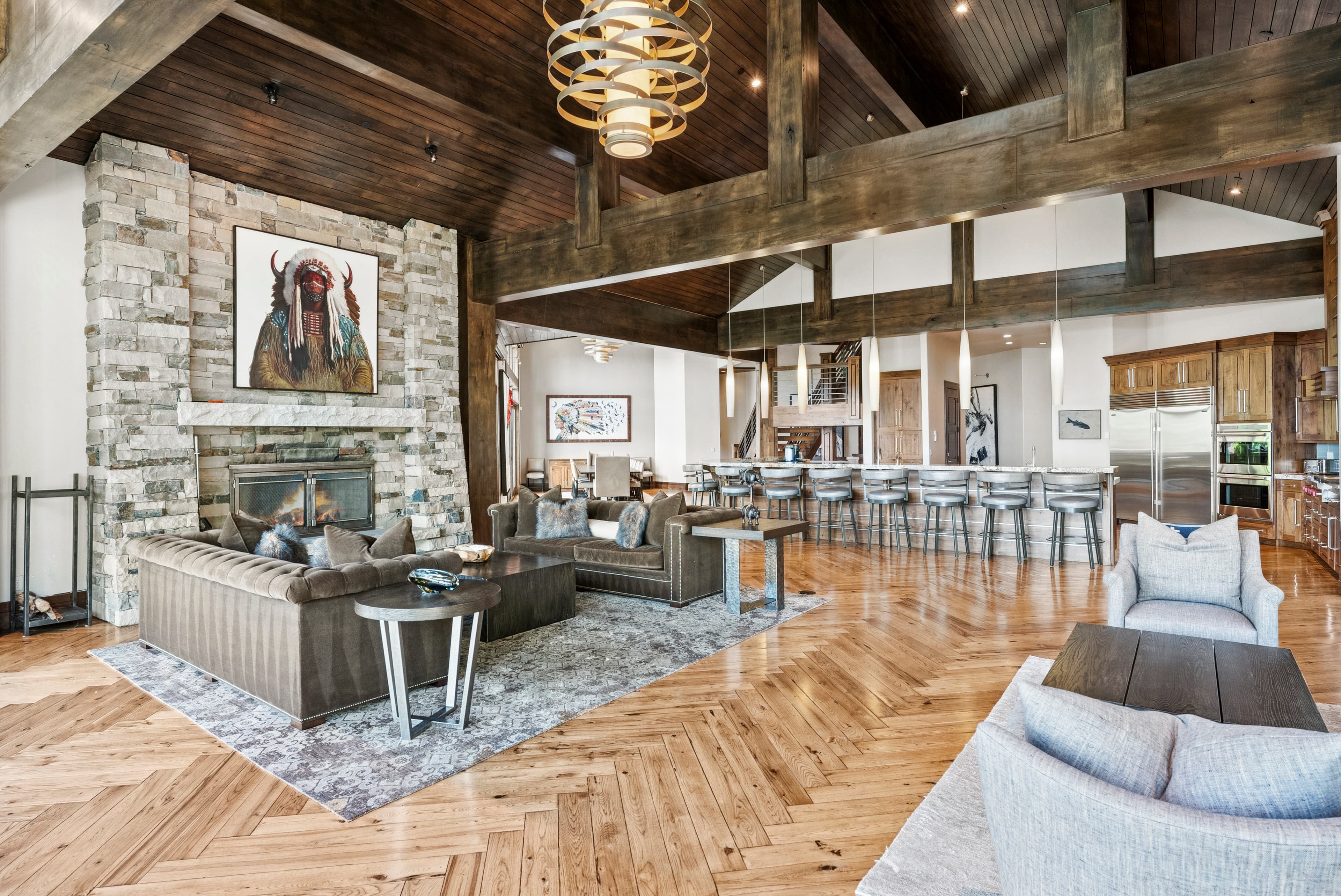 large seating area in front of a stone fireplace neck to a long bar with lots of seating - great entertaining space