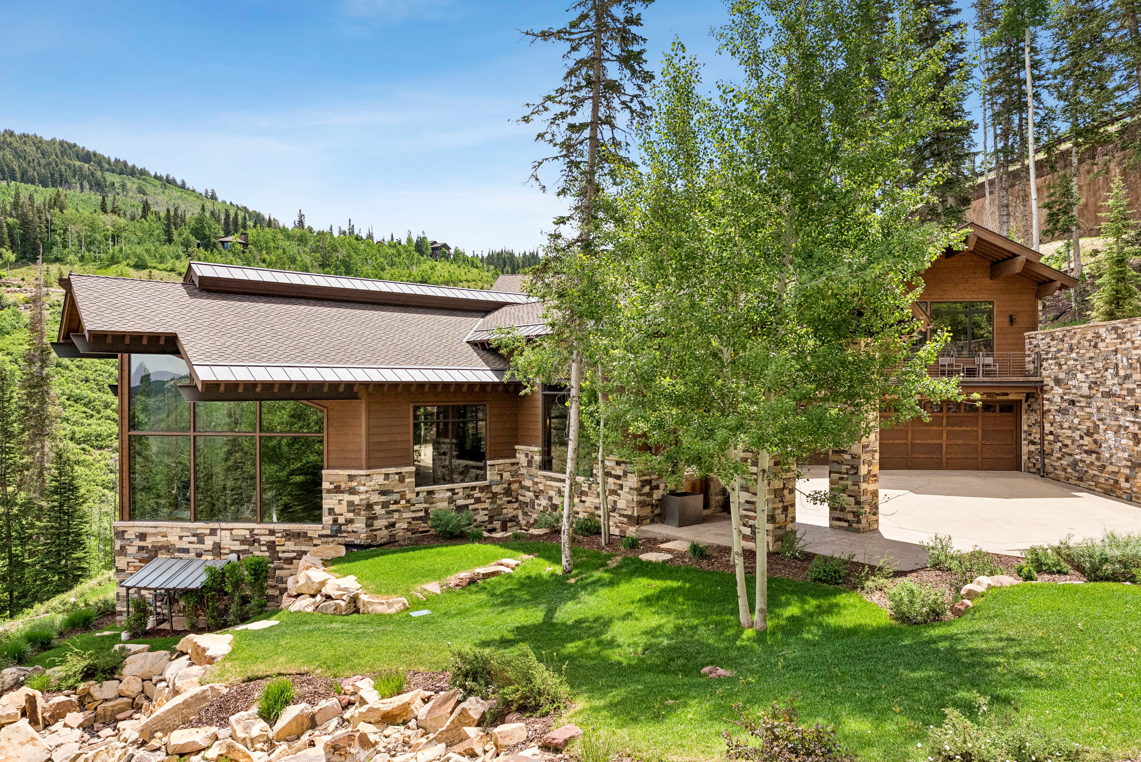 green lawn and mature landscaping in the front of grandview in park city
